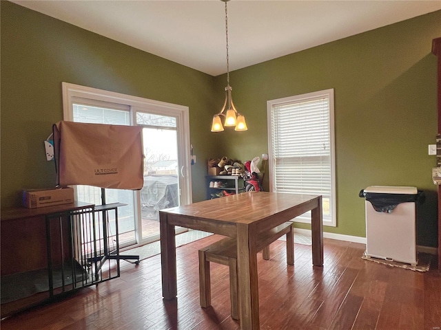 dining room with dark wood-type flooring and a chandelier