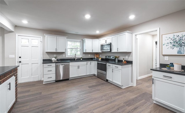 kitchen featuring white cabinets, dark hardwood / wood-style floors, sink, and appliances with stainless steel finishes