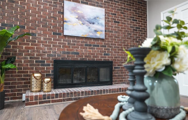 interior details featuring hardwood / wood-style floors and a brick fireplace