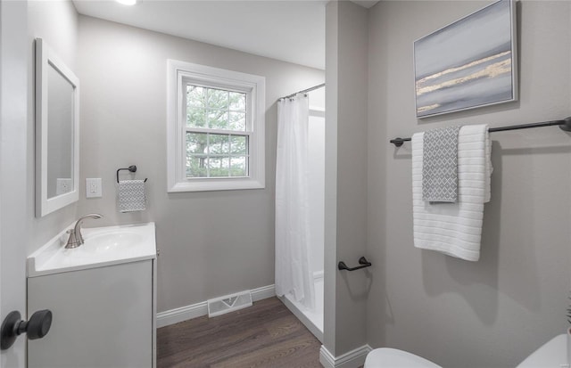 bathroom with curtained shower, vanity, wood-type flooring, and toilet