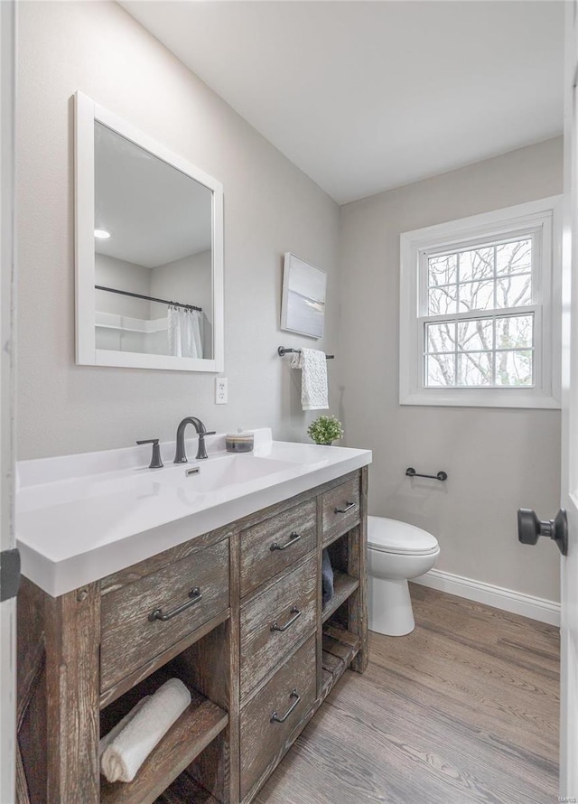 bathroom featuring wood-type flooring, vanity, and toilet