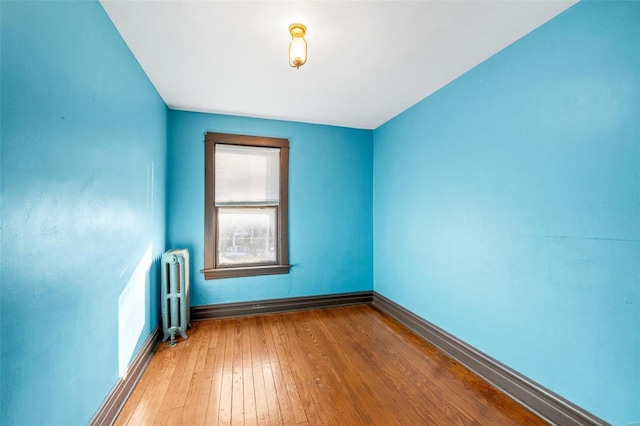 spare room with hardwood / wood-style flooring and radiator