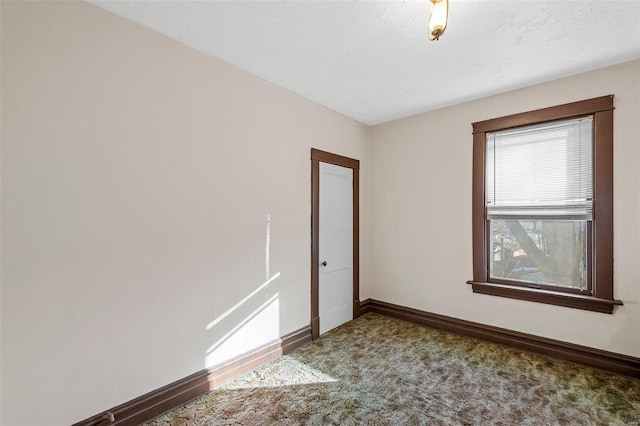 carpeted empty room with a textured ceiling