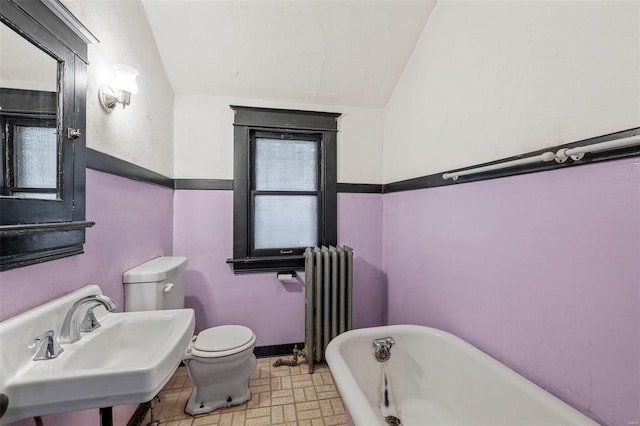 bathroom featuring sink, radiator heating unit, toilet, and a bathing tub