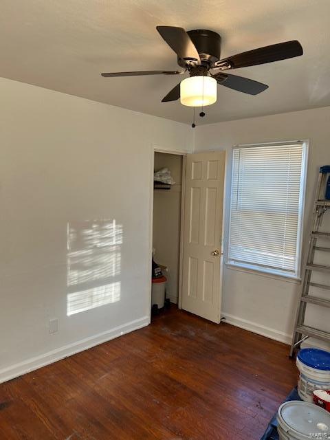 unfurnished bedroom with a closet, dark hardwood / wood-style floors, and ceiling fan