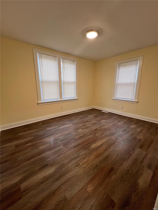 empty room with dark hardwood / wood-style floors