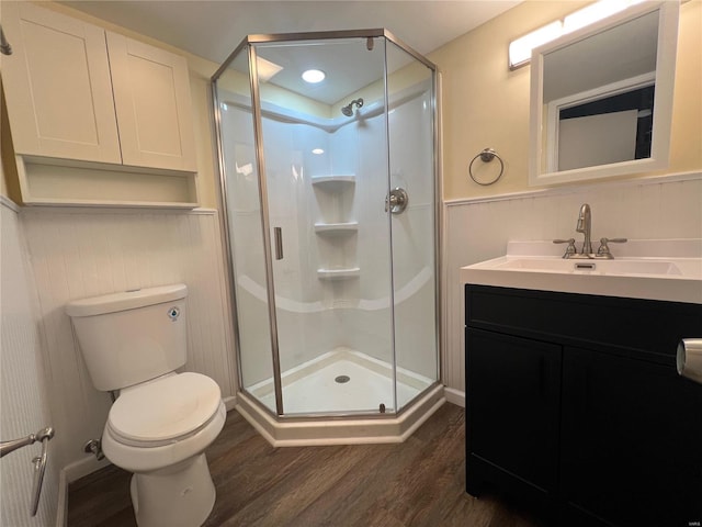 bathroom with toilet, hardwood / wood-style floors, vanity, and walk in shower