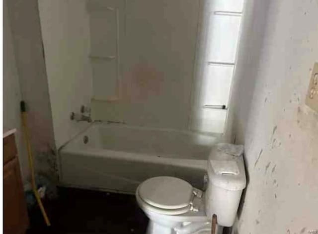 bathroom featuring toilet and washtub / shower combination