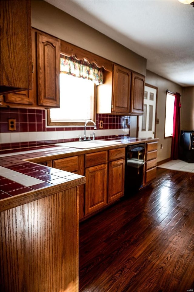 kitchen with backsplash, a healthy amount of sunlight, tile counters, and dark wood-type flooring