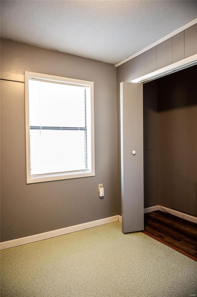 unfurnished bedroom with carpet flooring, a textured ceiling, and a closet