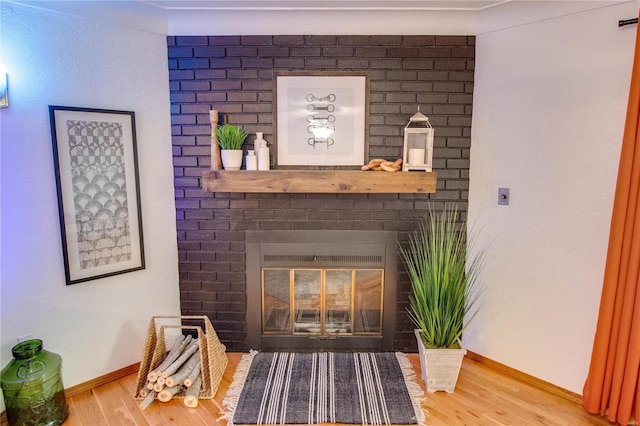 interior details featuring wood-type flooring and a brick fireplace