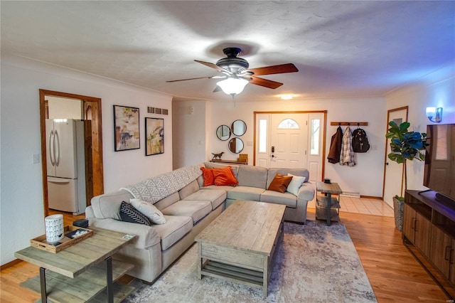 living room with ceiling fan, light wood-type flooring, and ornamental molding