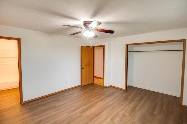 unfurnished bedroom with hardwood / wood-style floors, ceiling fan, and a closet