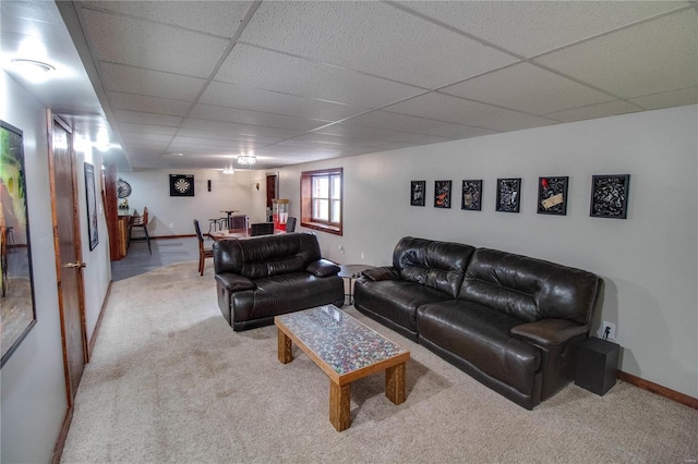 living room with a paneled ceiling and light carpet