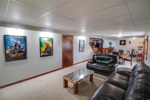 carpeted living room featuring a drop ceiling