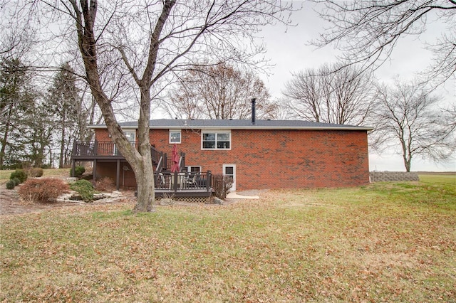 rear view of house with a lawn and a wooden deck