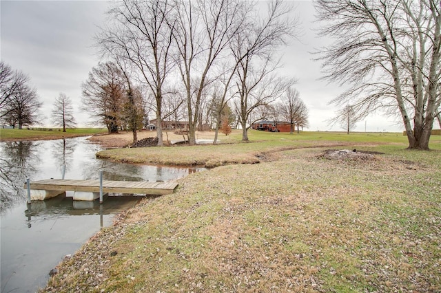 dock area with a lawn and a water view