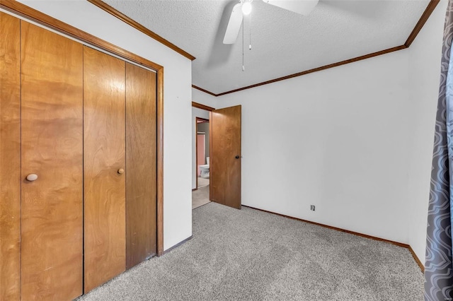 unfurnished bedroom featuring ceiling fan, light colored carpet, a textured ceiling, and a closet