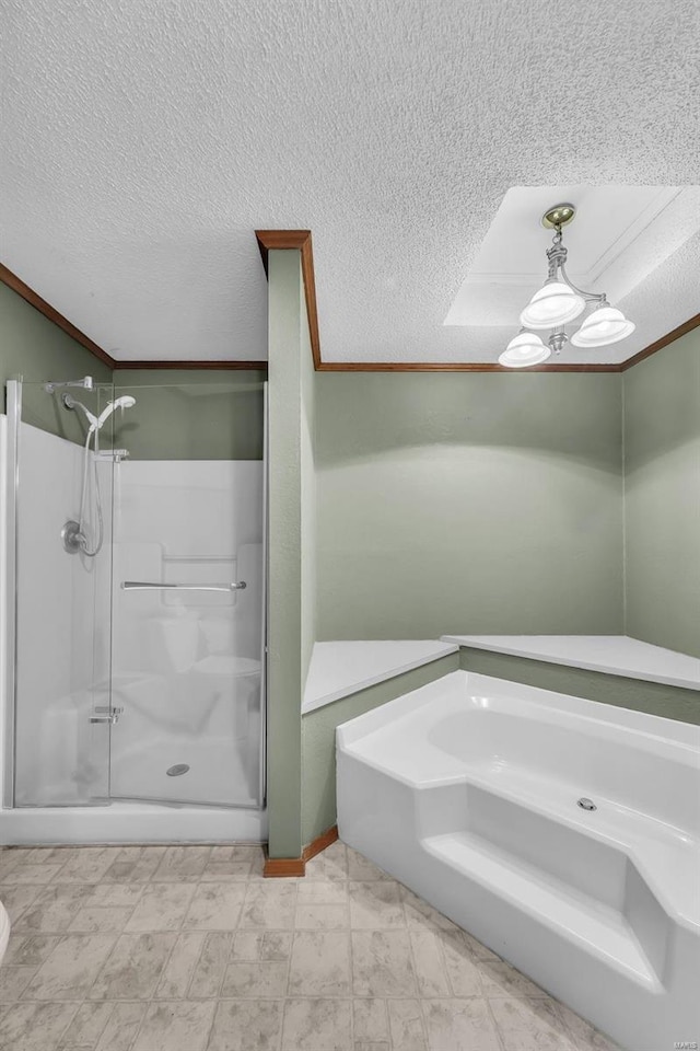 bathroom featuring a textured ceiling, separate shower and tub, and crown molding