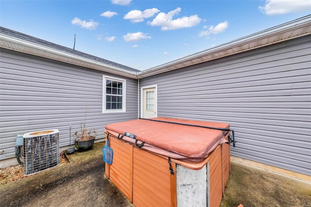 exterior space featuring cooling unit and a hot tub