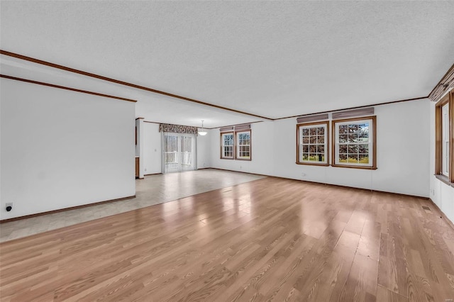 unfurnished living room with a textured ceiling and light hardwood / wood-style floors