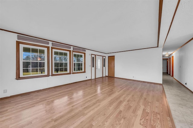 unfurnished living room with light hardwood / wood-style floors and ornamental molding