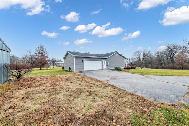 view of side of property with a garage and a lawn