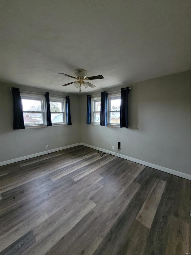 spare room featuring a wealth of natural light, dark wood-type flooring, and ceiling fan