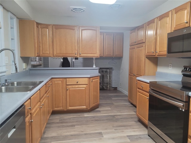 kitchen with light wood-type flooring, stainless steel appliances, backsplash, and sink