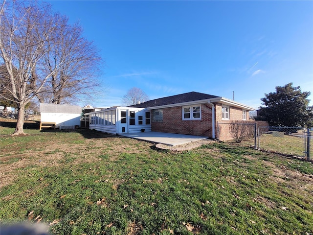 back of property with a patio, a sunroom, and a lawn