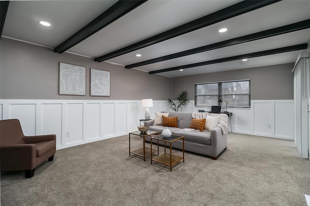 living room with beam ceiling and light colored carpet