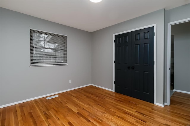 unfurnished bedroom with a closet and light hardwood / wood-style floors