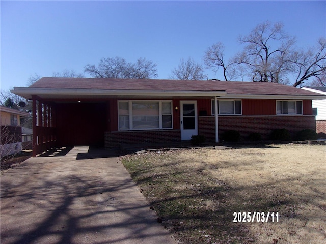 view of front of home with a carport, brick siding, and driveway