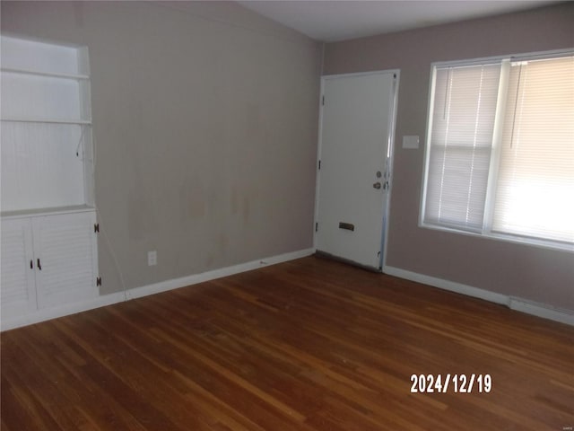 unfurnished room with baseboards and wood finished floors