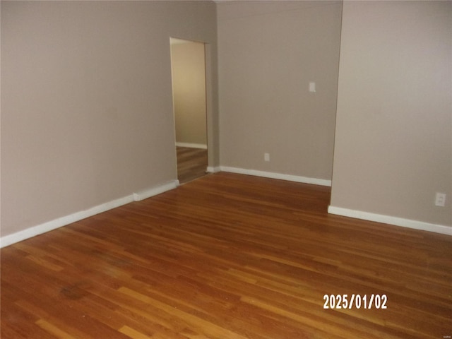 unfurnished room with baseboards and wood finished floors