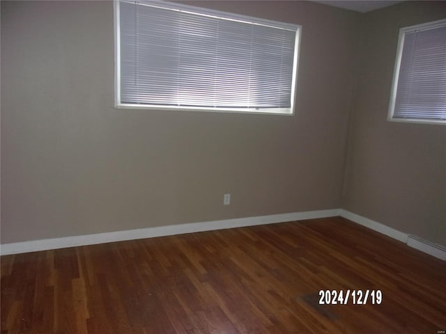 unfurnished room featuring baseboards and wood finished floors