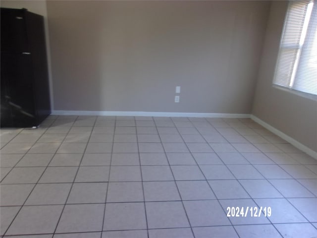 empty room with baseboards and light tile patterned flooring