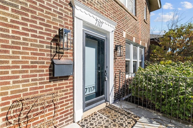 doorway to property with brick siding