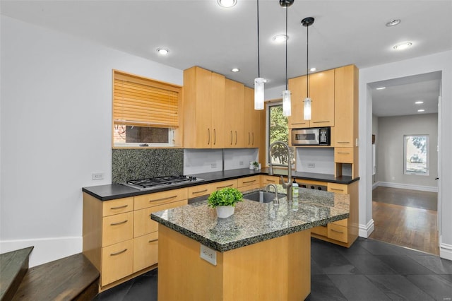 kitchen featuring an island with sink, light brown cabinets, appliances with stainless steel finishes, and a sink