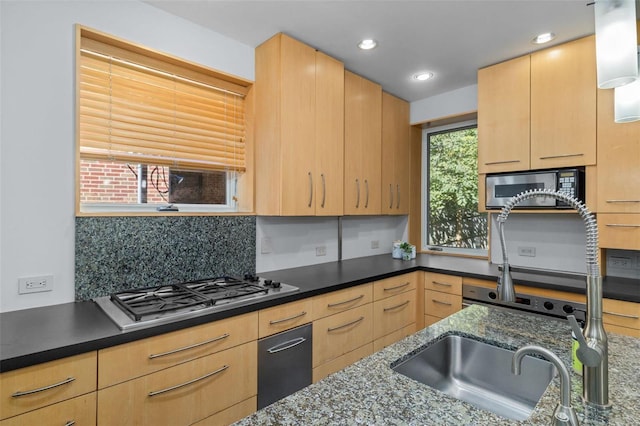 kitchen featuring decorative backsplash, light brown cabinets, and appliances with stainless steel finishes