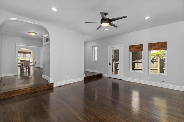 unfurnished living room featuring arched walkways, visible vents, recessed lighting, and wood finished floors