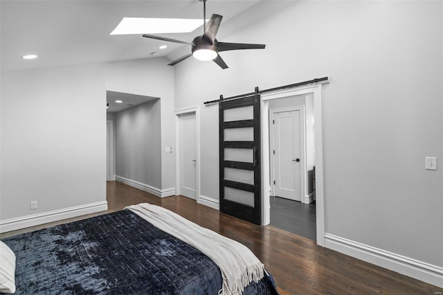 bedroom with wood finished floors, recessed lighting, a barn door, a skylight, and baseboards