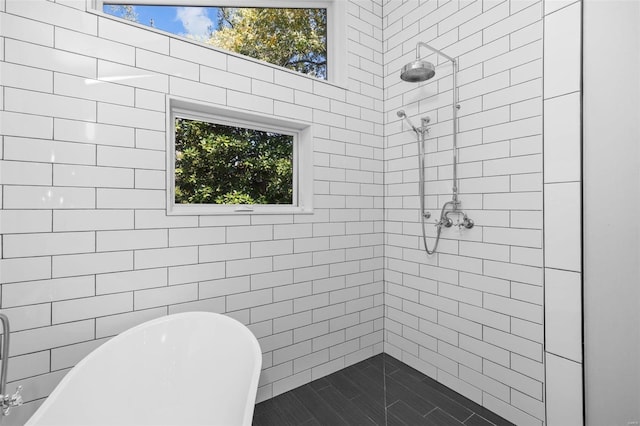 full bath featuring a freestanding tub, tiled shower, and plenty of natural light