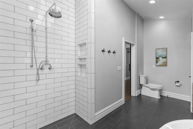 full bath with toilet, wood finished floors, a tile shower, recessed lighting, and baseboards