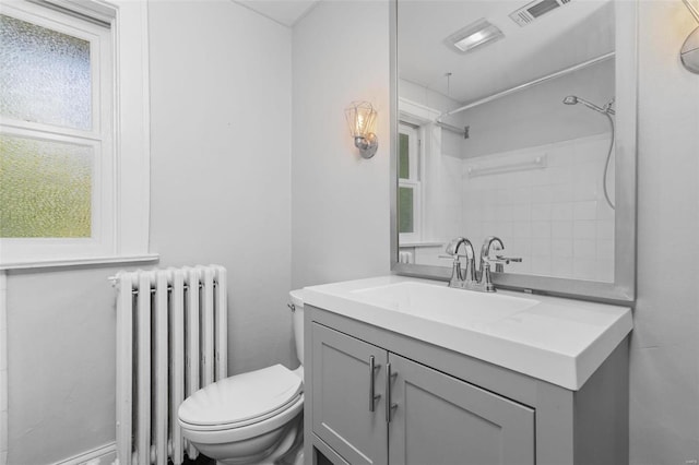 bathroom with visible vents, vanity, toilet, and radiator heating unit