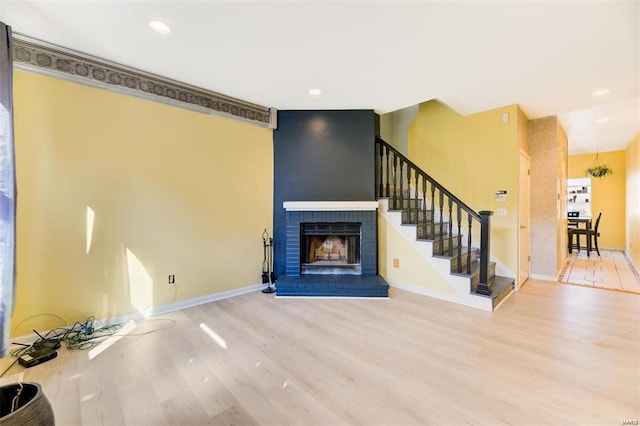 unfurnished living room with hardwood / wood-style floors and a brick fireplace