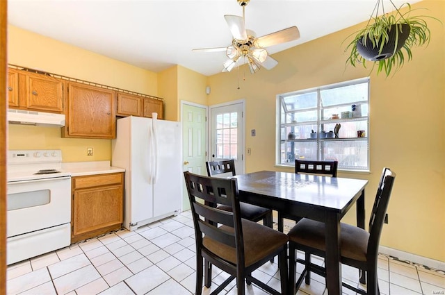 kitchen featuring light tile patterned floors, white appliances, and ceiling fan