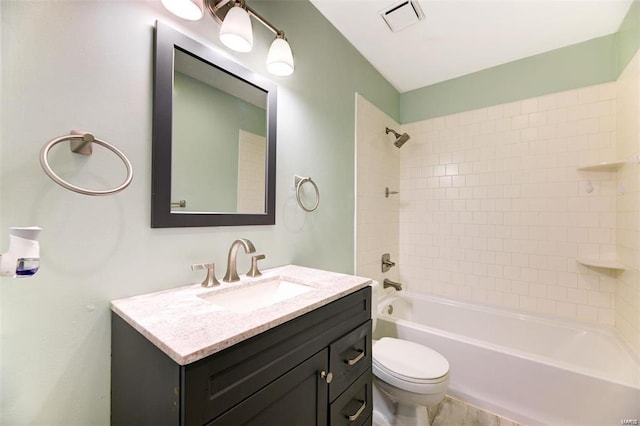 full bathroom featuring vanity, tiled shower / bath combo, and toilet