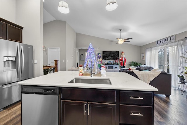 kitchen with sink, appliances with stainless steel finishes, dark hardwood / wood-style floors, an island with sink, and vaulted ceiling