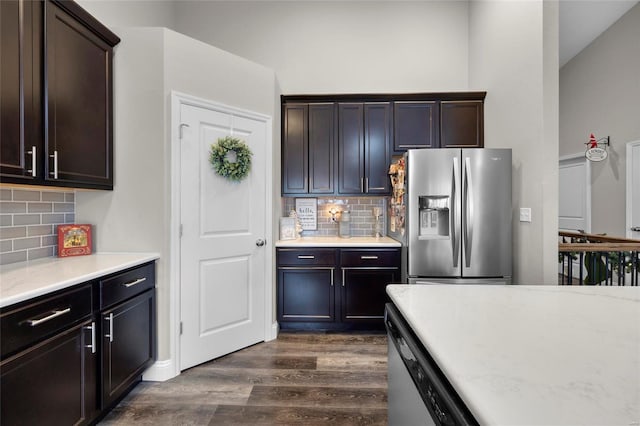 kitchen with dishwasher, decorative backsplash, dark wood-type flooring, stainless steel refrigerator with ice dispenser, and dark brown cabinets